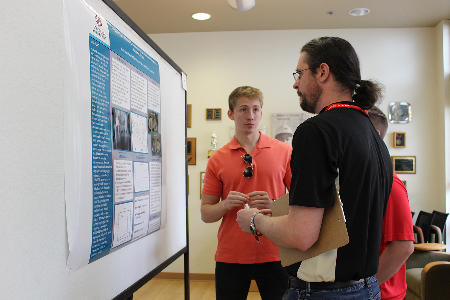 photo: a student presents their poster for judging