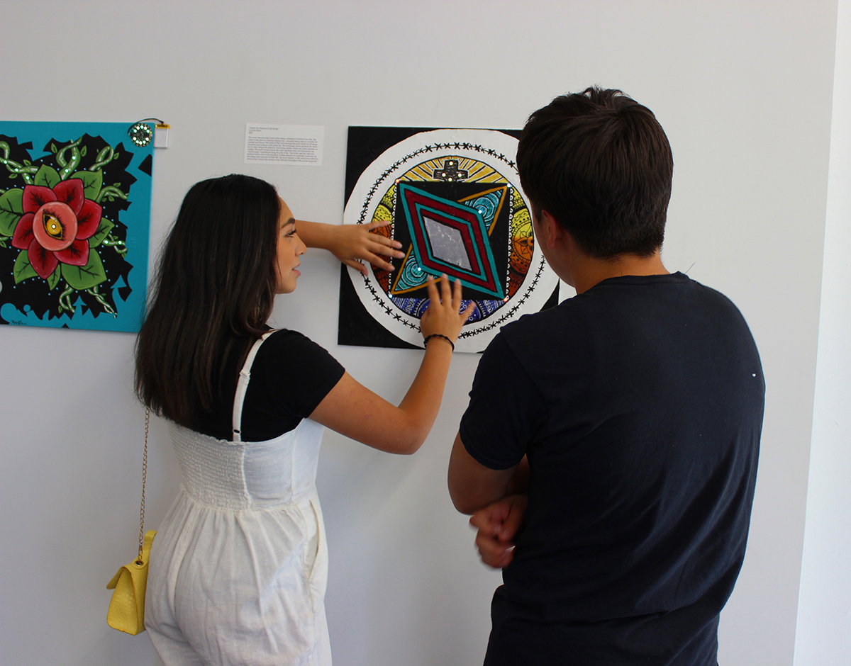Photo: Student Carmelia Rubio demonstrates her artwork.