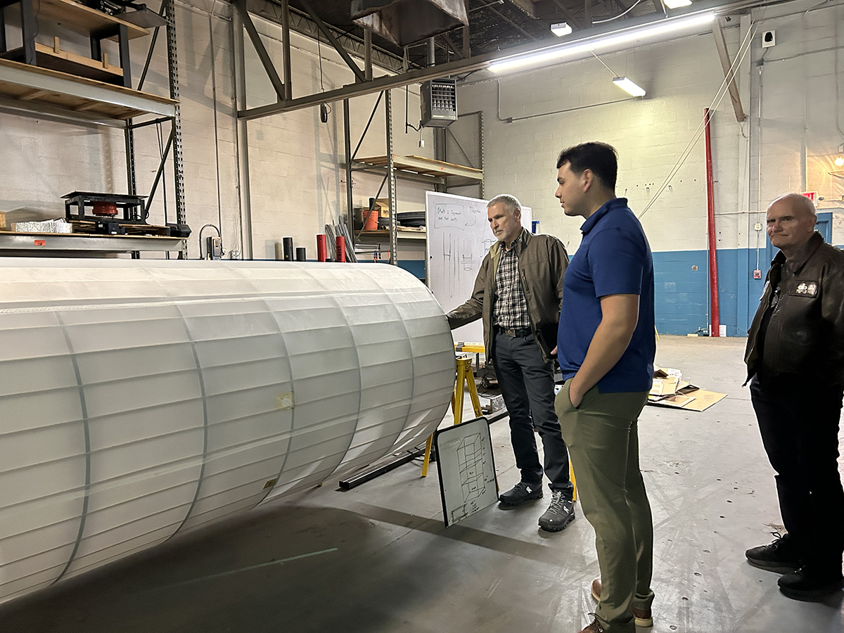 photo: Bret Simpkins, a supporter of the Lobo Launch program and an alumnus of the Department of Nuclear Engineering, inspects one of the rockets with Christopher Solis and Doc Aguilar at their build space near campus.
