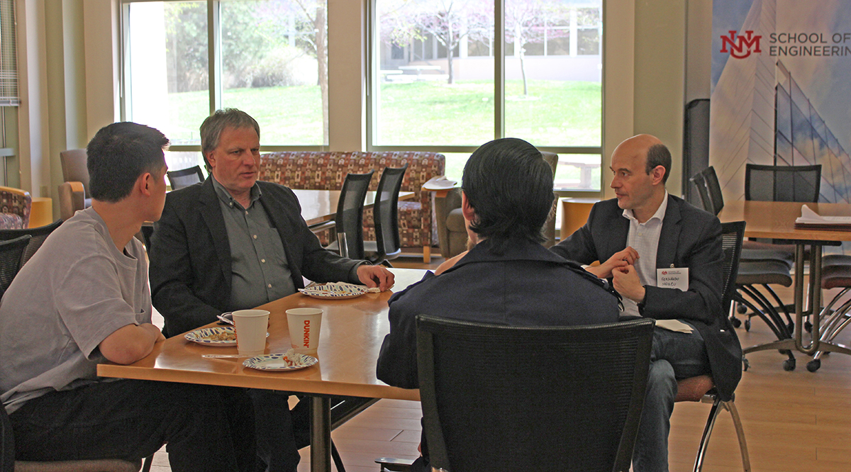 photo: Mark Gilmore, chair of the Department of Electrical and Computer Engineering, and Fernando Moreu, assistant professor in the Gerald May Department of Civil, Construction and Environmental Engineering, talk at lunch with a couple of prospective students about graduate studies opportunities in the School.