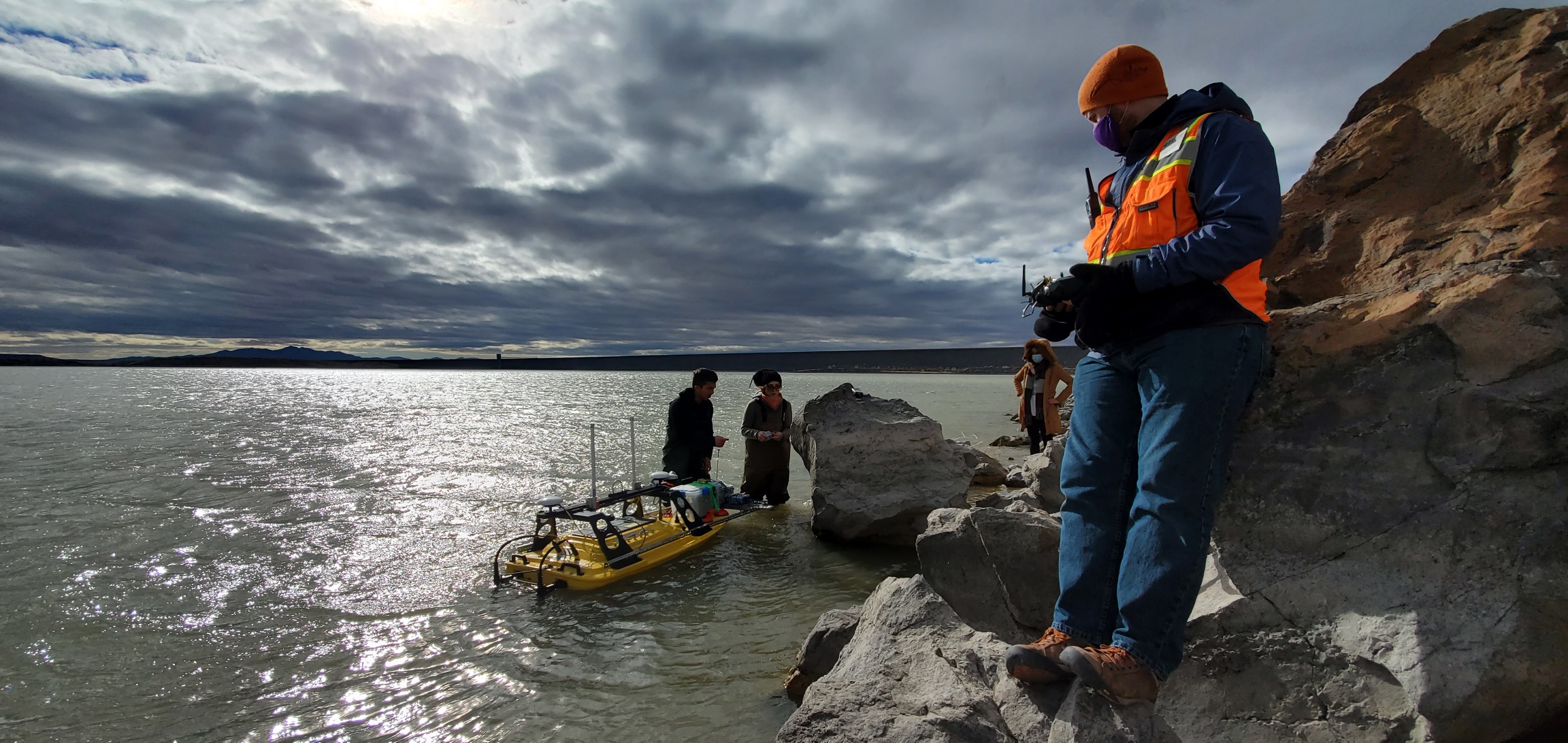 photo: students with drone, outdoors at a waterfront