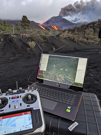 photo: laptop with research information in front of volcano