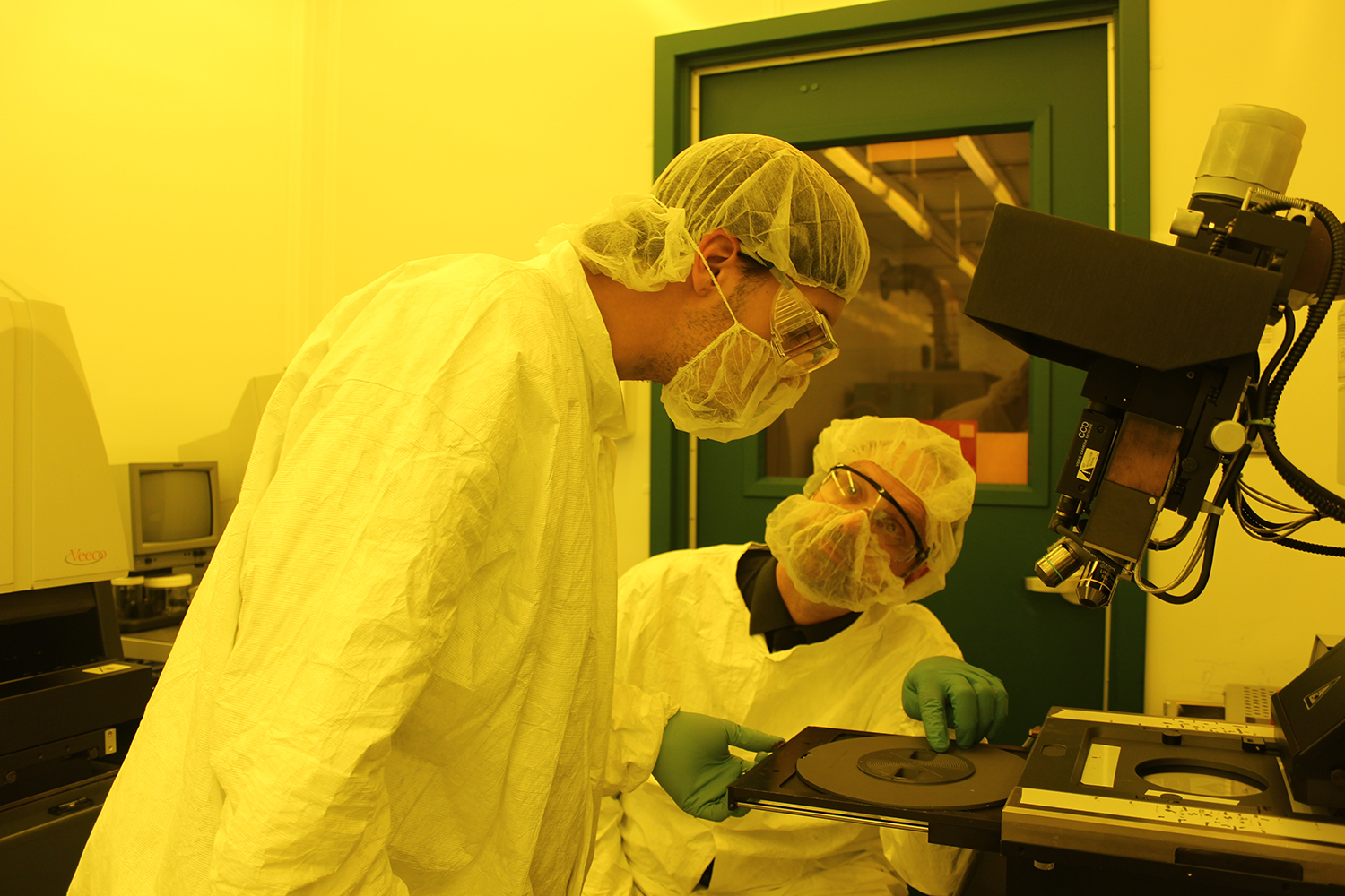Photo:  Matt Pleil works with a student in the MTTC cleanroom at UNM.