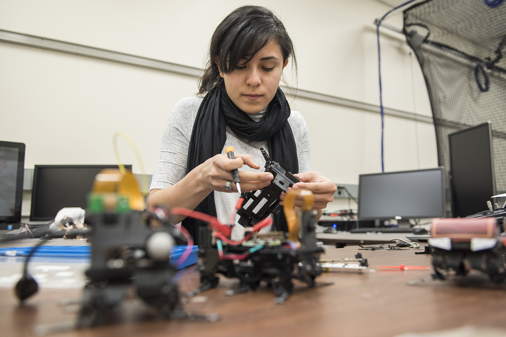 photo: a woman working with electronic components in a laboratory setting.