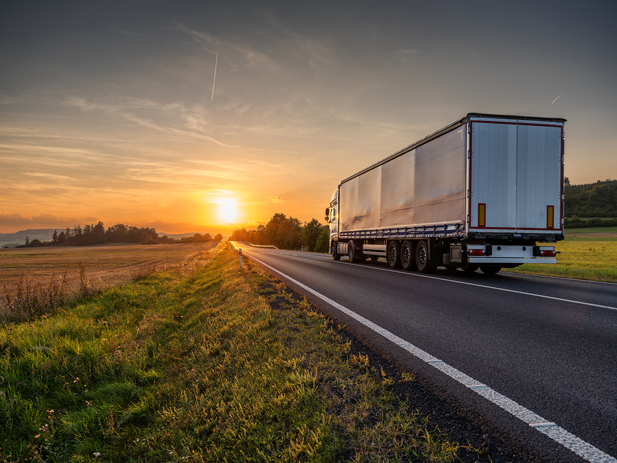 photo: a commercial truck driving through a rural setting.