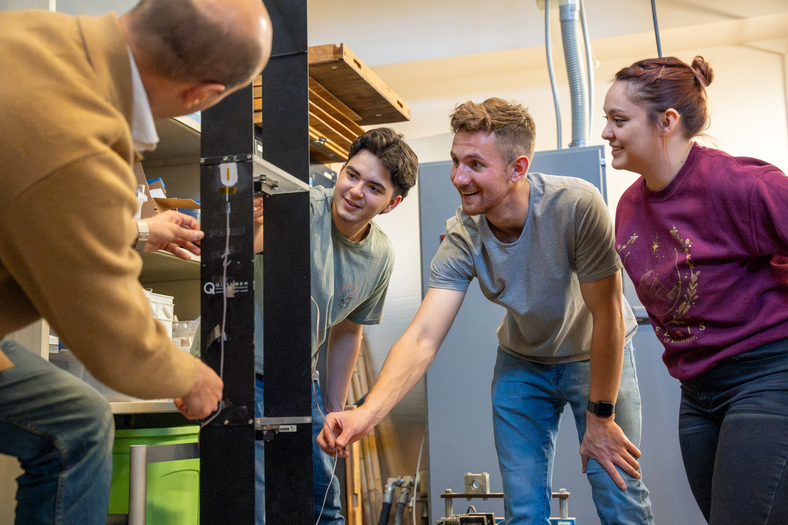 photo: Associate Professor Fernando Moreu (right) shows Michael Carl, an undergraduate student in the Department of Computer Science, and Wyatt Saeger, a 2nd year Civil Engineering master’s student, and Gabriella Gallegos, a 2nd year Civil Engineering master’s student, the hydraulic actuator, which helps his lab study earthquakes and structural dynamics.