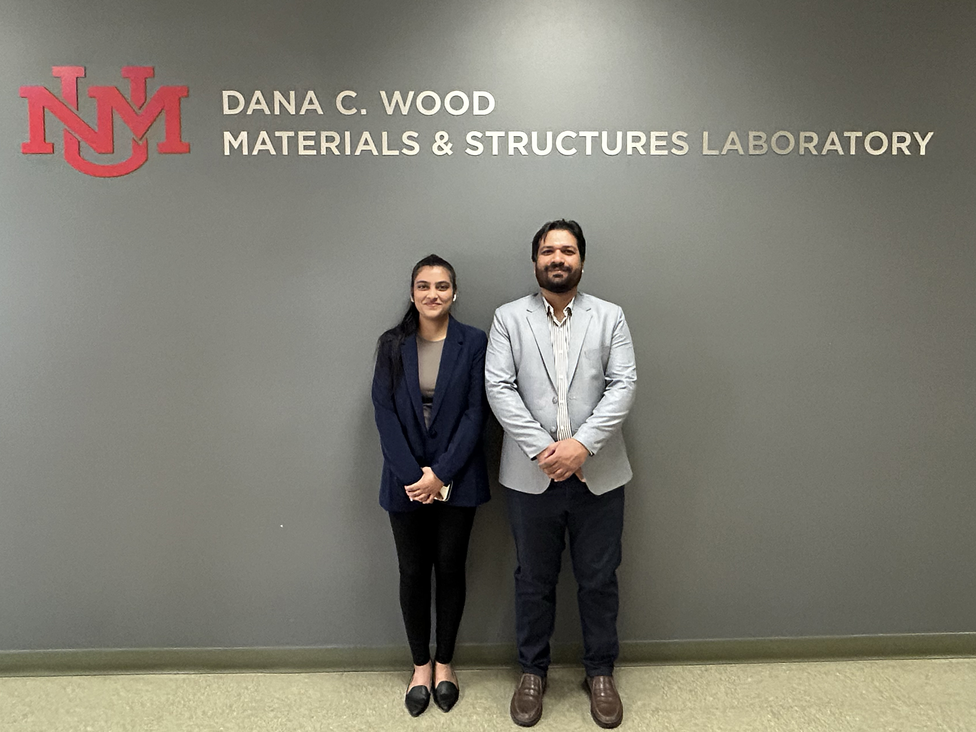 photo: Sneha Gupta (left) and Tayyab Zafar stand under the sign of the lab where they performed their award-winning research.
